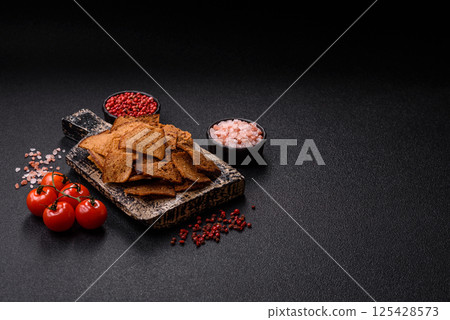 Crispy homemade brown bread chips with seeds and grains 125428573