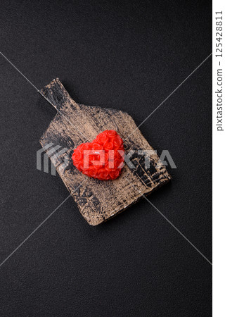 Red wax candle in the shape of a heart as decor for Valentine's Day Red wax candle in the shape of a heart as decor for Valentine's Day 125428811
