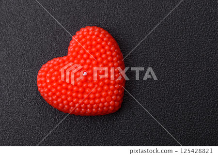 Red wax candle in the shape of a heart as decor for Valentine's Day Red wax candle in the shape of a heart as decor for Valentine's Day 125428821