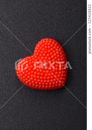 Red wax candle in the shape of a heart as decor for Valentine's Day 125428822