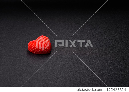 Red wax candle in the shape of a heart as decor for Valentine's Day 125428824