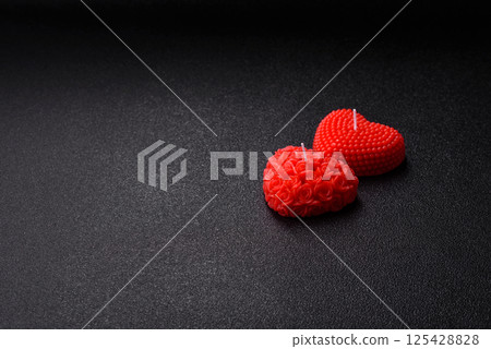 Red wax candle in the shape of a heart as decor for Valentine's Day Red wax candle in the shape of a heart as decor for Valentine's Day 125428828