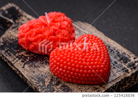 Red wax candle in the shape of a heart as decor for Valentine's Day Red wax candle in the shape of a heart as decor for Valentine's Day 125428836
