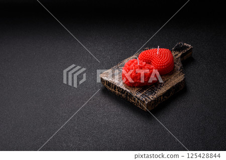 Red wax candle in the shape of a heart as decor for Valentine's Day 125428844