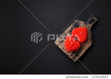 Red wax candle in the shape of a heart as decor for Valentine's Day 125428845