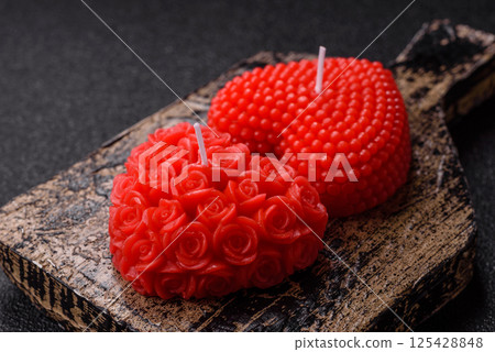 Red wax candle in the shape of a heart as decor for Valentine's Day Red wax candle in the shape of a heart as decor for Valentine's Day 125428848