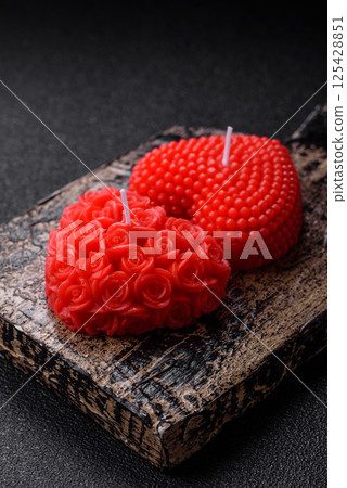Red wax candle in the shape of a heart as decor for Valentine's Day 125428851