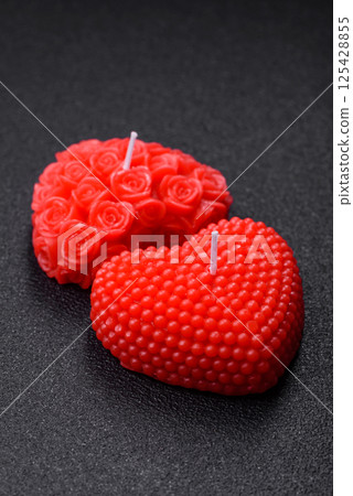Red wax candle in the shape of a heart as decor for Valentine's Day 125428855
