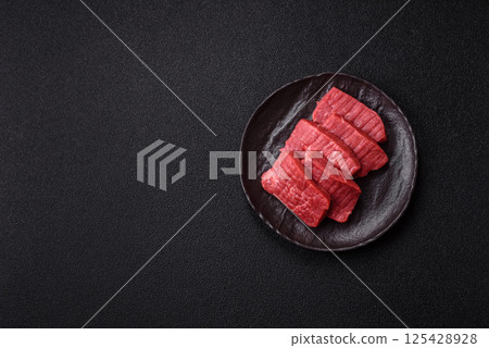 Raw beef tenderloin cut into slices with salt and spices 125428928