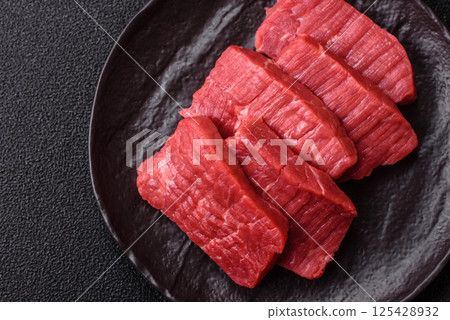 Raw beef tenderloin cut into slices with salt and spices Raw beef tenderloin cut into slices with salt and spices 125428932