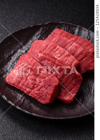 Raw beef tenderloin cut into slices with salt and spices Raw beef tenderloin cut into slices with salt and spices 125428934