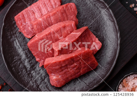 Raw beef tenderloin cut into slices with salt and spices Raw beef tenderloin cut into slices with salt and spices 125428936