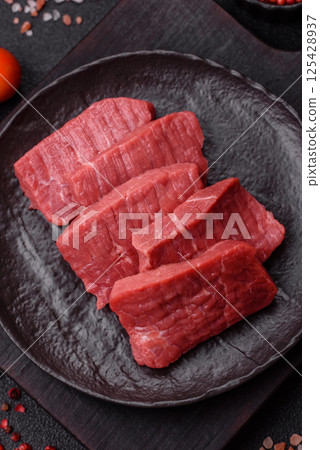 Raw beef tenderloin cut into slices with salt and spices Raw beef tenderloin cut into slices with salt and spices 125428937