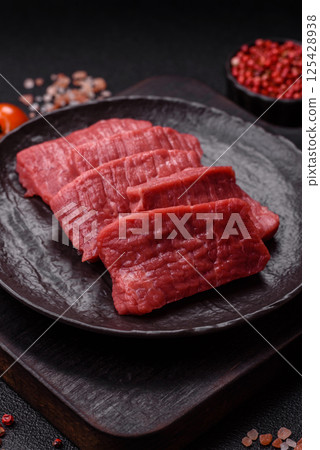 Raw beef tenderloin cut into slices with salt and spices 125428938