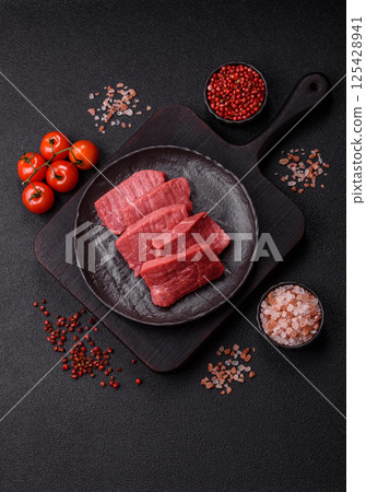 Raw beef tenderloin cut into slices with salt and spices 125428941