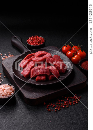 Raw beef tenderloin cut into slices with salt and spices Raw beef tenderloin cut into slices with salt and spices 125428946