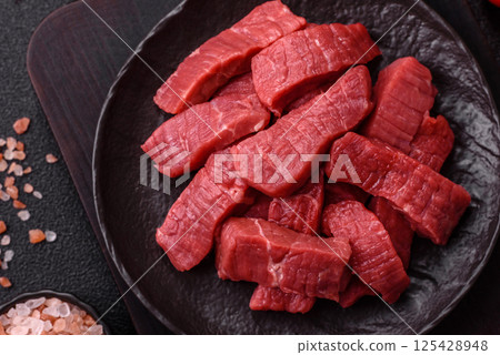 Raw beef tenderloin cut into slices with salt and spices 125428948