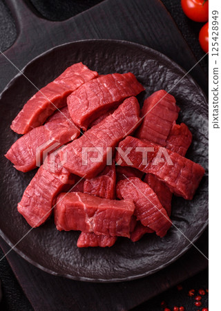 Raw beef tenderloin cut into slices with salt and spices 125428949