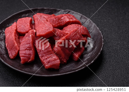 Raw beef tenderloin cut into slices with salt and spices 125428951