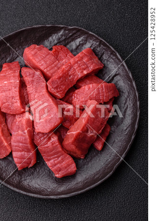 Raw beef tenderloin cut into slices with salt and spices Raw beef tenderloin cut into slices with salt and spices 125428952