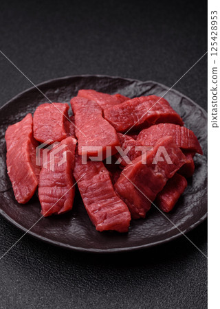 Raw beef tenderloin cut into slices with salt and spices Raw beef tenderloin cut into slices with salt and spices 125428953