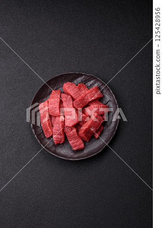 Raw beef tenderloin cut into slices with salt and spices Raw beef tenderloin cut into slices with salt and spices 125428956