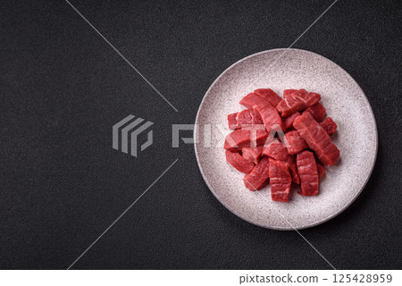 Raw beef tenderloin cut into slices with salt and spices Raw beef tenderloin cut into slices with salt and spices 125428959