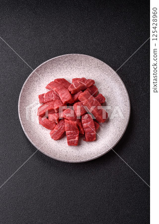 Raw beef tenderloin cut into slices with salt and spices Raw beef tenderloin cut into slices with salt and spices 125428960
