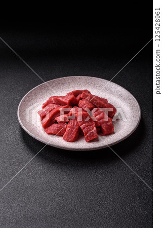 Raw beef tenderloin cut into slices with salt and spices Raw beef tenderloin cut into slices with salt and spices 125428961