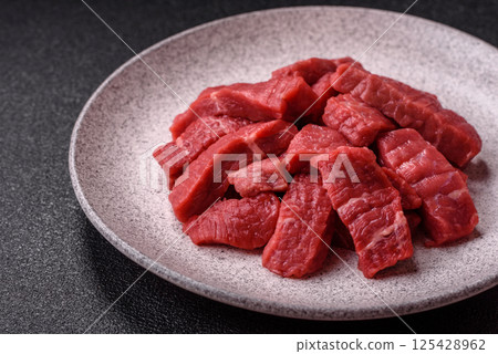 Raw beef tenderloin cut into slices with salt and spices 125428962