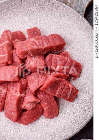 Raw beef tenderloin cut into slices with salt and spices 125428967