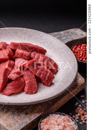 Raw beef tenderloin cut into slices with salt and spices Raw beef tenderloin cut into slices with salt and spices 125428968