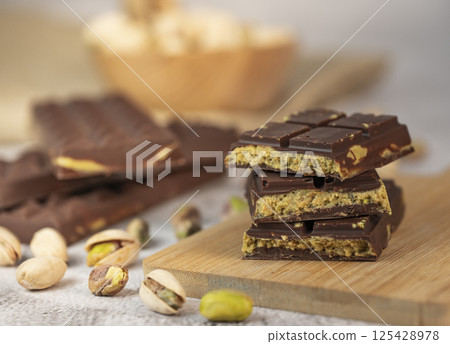 Delicious chocolate bar with pistachio pieces showcased in a Dubai setting, perfect for dessert Delicious chocolate bar with pistachio pieces showcased in a Dubai setting, perfect for dessert 125428978