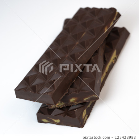 Delicious kadaif layers with rich chocolate and pistachio topping displayed on a clean, white Delicious kadaif layers with rich chocolate and pistachio topping displayed on a clean, white 125428988