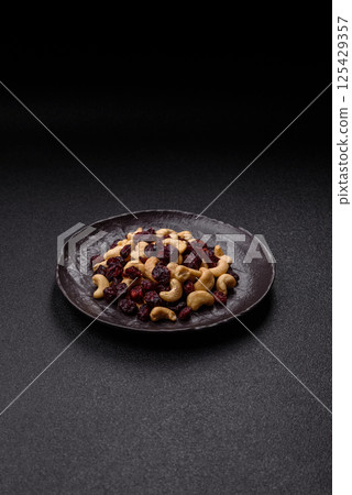 Mixture of roasted cashews and dried cranberries 125429357
