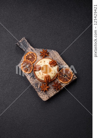 Sweet round tart with white citrus cream and pecans Sweet round tart with white citrus cream and pecans 125429421