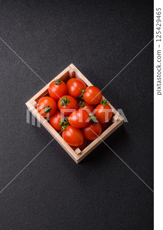 Ripe red cherry tomatoes in a wooden box 125429465