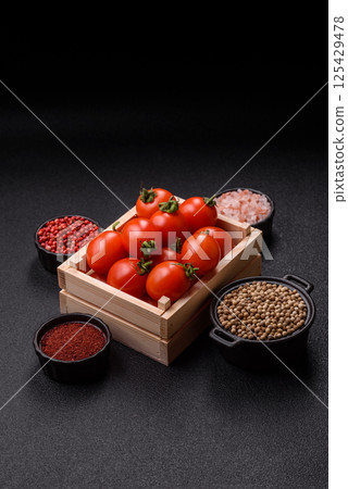 Ripe red cherry tomatoes in a wooden box Ripe red cherry tomatoes in a wooden box 125429478
