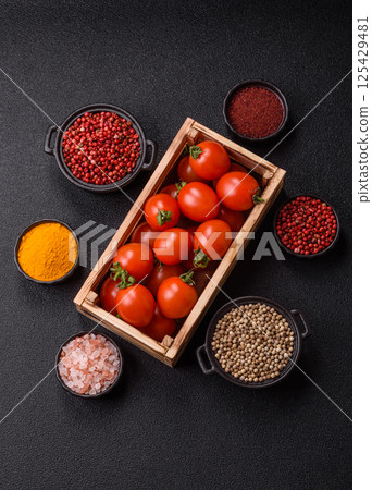 Ripe red cherry tomatoes in a wooden box 125429481