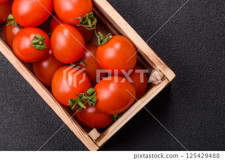 Ripe red cherry tomatoes in a wooden box 125429488