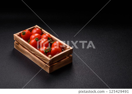 Ripe red cherry tomatoes in a wooden box 125429491