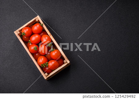 Ripe red cherry tomatoes in a wooden box 125429492