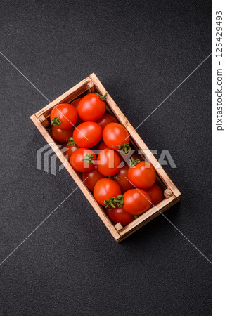 Ripe red cherry tomatoes in a wooden box 125429493