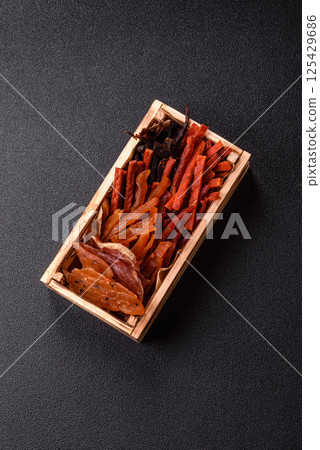Jerky, dried fish in the form of sticks with salt, spices and herbs 125429686