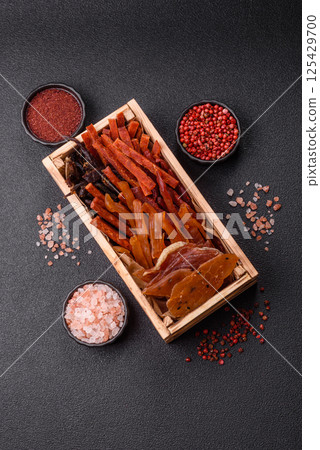 Jerky, dried fish in the form of sticks with salt, spices and herbs 125429700