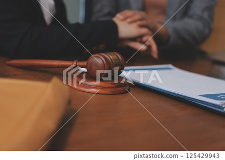 Judge gavel with Justice lawyers having team meeting at law firm background. Concepts of Law and Legal services. 125429943