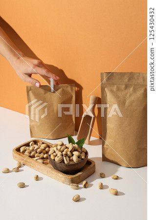 Pistachios in a craft bag, on a yellow background. Pistachios in a craft bag, on a yellow background. 125430432