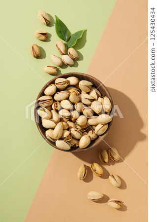 Pistachios in a plate, on a green background. Pistachios in a plate, on a green background. 125430434