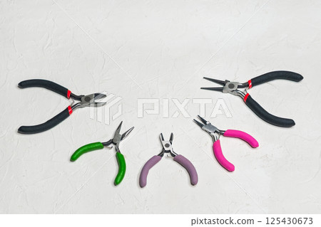 Various wire cutters are laid out on a white 125430673