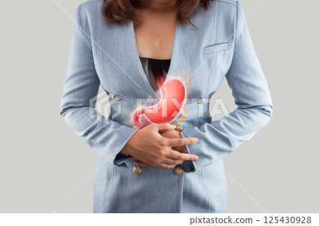Woman suffers from acid reflux symptom in upper abdominal area. 125430928